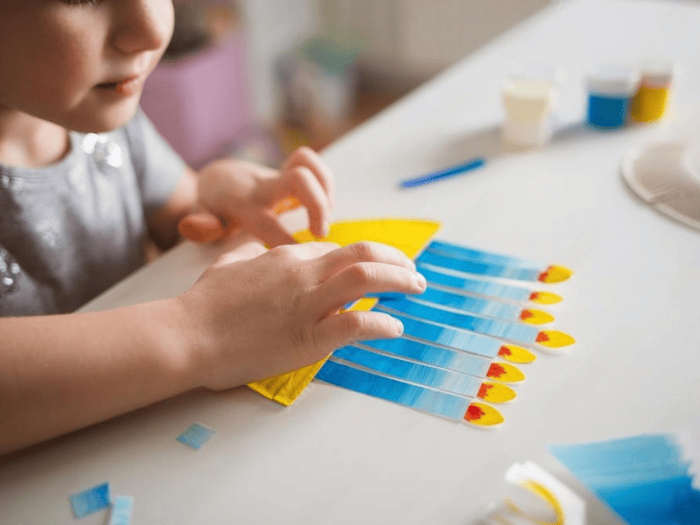 Kid making a DIY Hanukkah candles