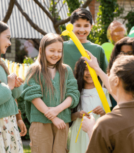 Person giving balloons to kids
