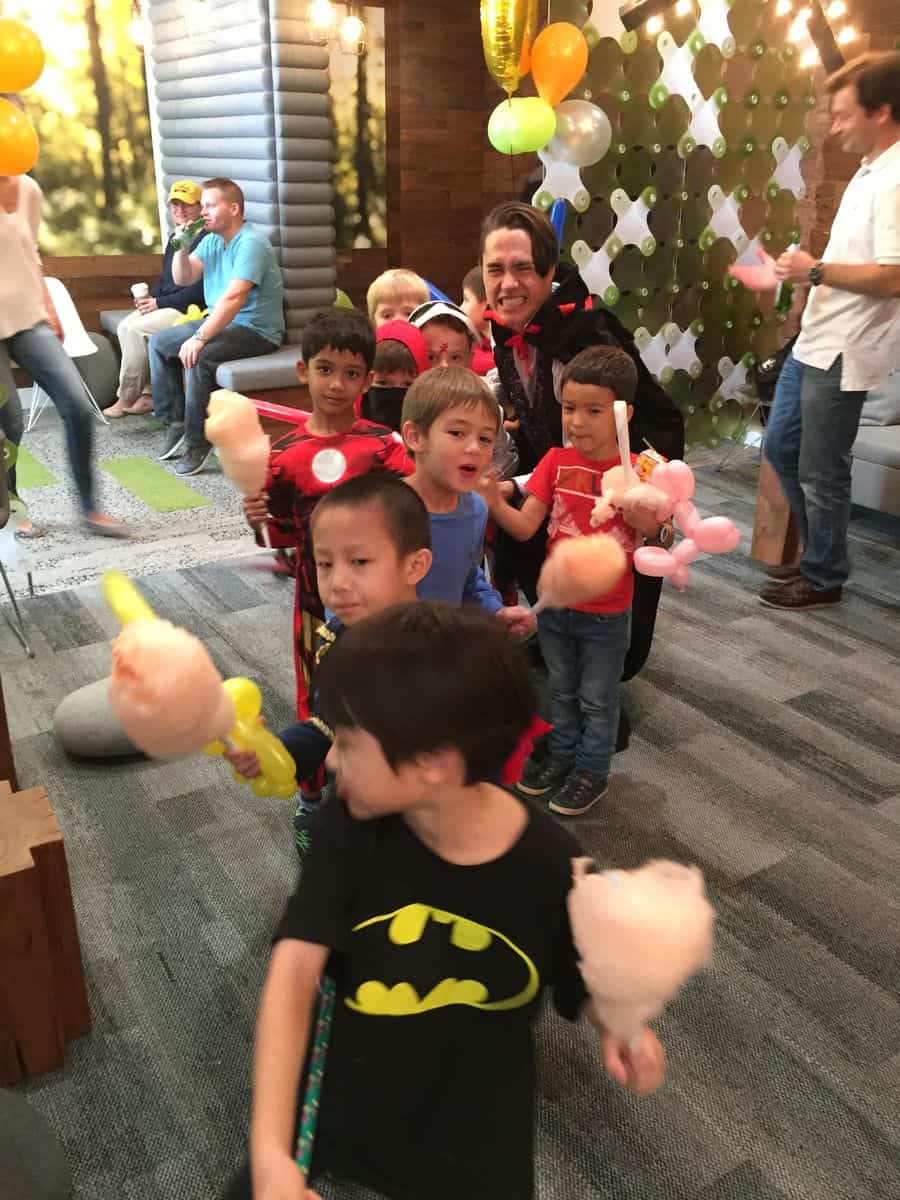 Kids dancing with cotton candy and balloons at a Halloween party